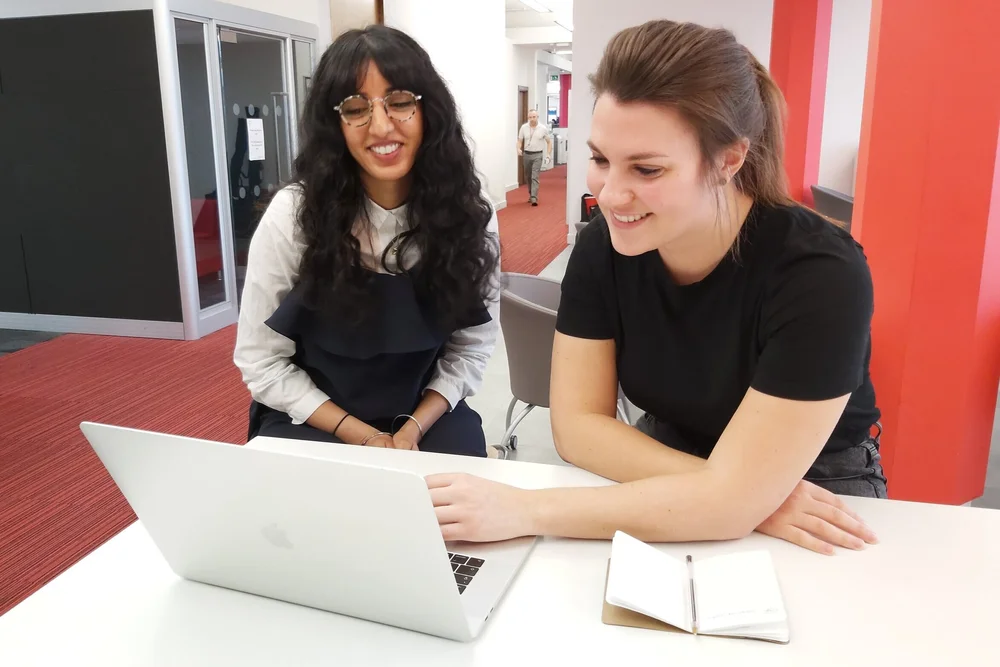 Usability testing session: two women smiling at a laptop