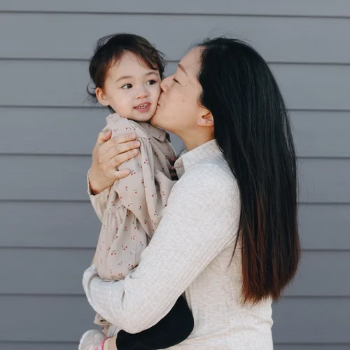 Ava, a mother holding her young daughter