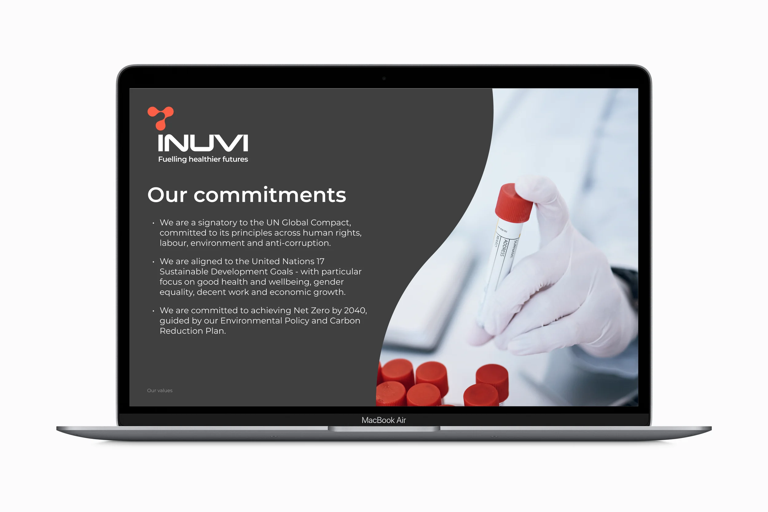 Inuvi slide deck on a laptop: an &lsquo;Our commitments&rsquo; slide on dark grey, with a gloved hand holding a red-capped sample tube inside the curved frame