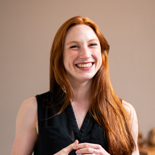 Persona photo: a smiling woman with long red hair, representing the employee