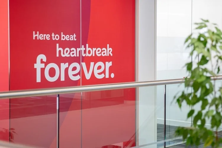British Heart Foundation "Here to beat heartbreak forever" sign on a red wall