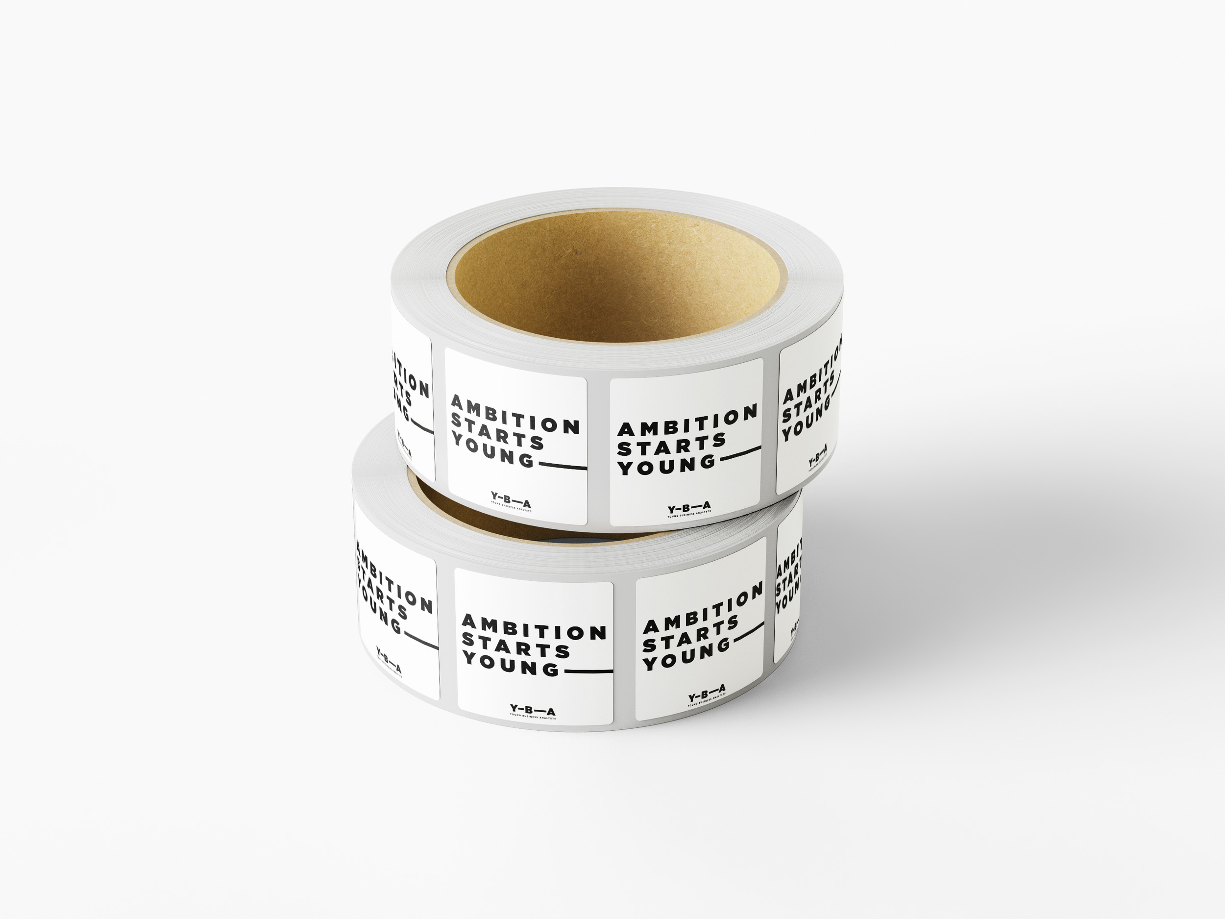 Two stacked rolls of square YBA stickers reading &lsquo;Ambition starts young&rsquo; with the extending line and the YBA logo